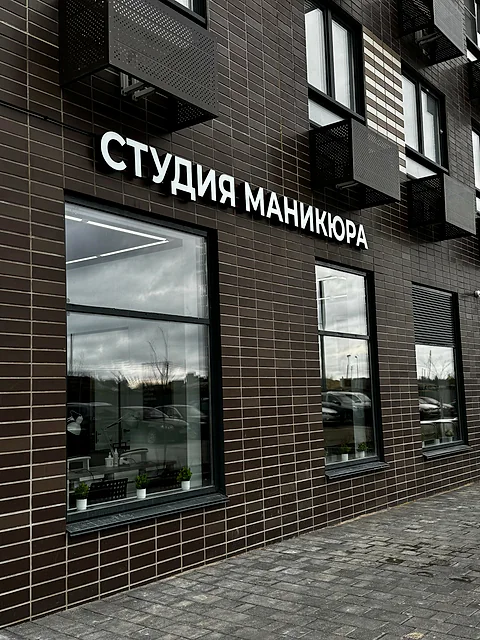 Фасад здания с крупной вывеской «Студия маникюра»